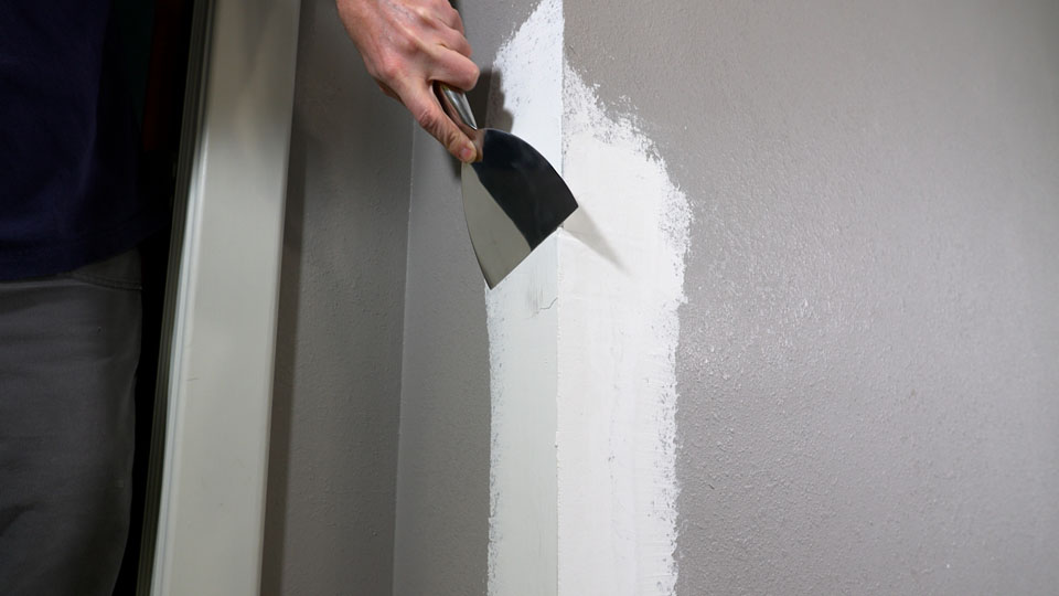 scraping away the high spots with a joint knife